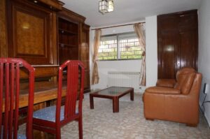 Salón con ventana, sillón y mueble de madera