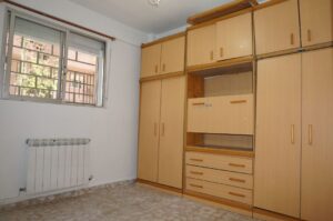Dormitorio con armario y ventana