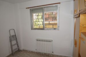 Dormitorio con ventana y radiador