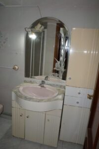 Baño con lavabo y mueble auxiliar