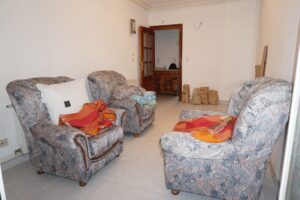 Salón con tresillo y puerta al recibidor