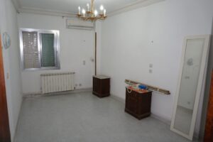 Dormitorio con ventana, radiador y aire acondicionado